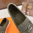 Hermes suede loafer upper in dark olive green, close-up of metal bit and stitched laces