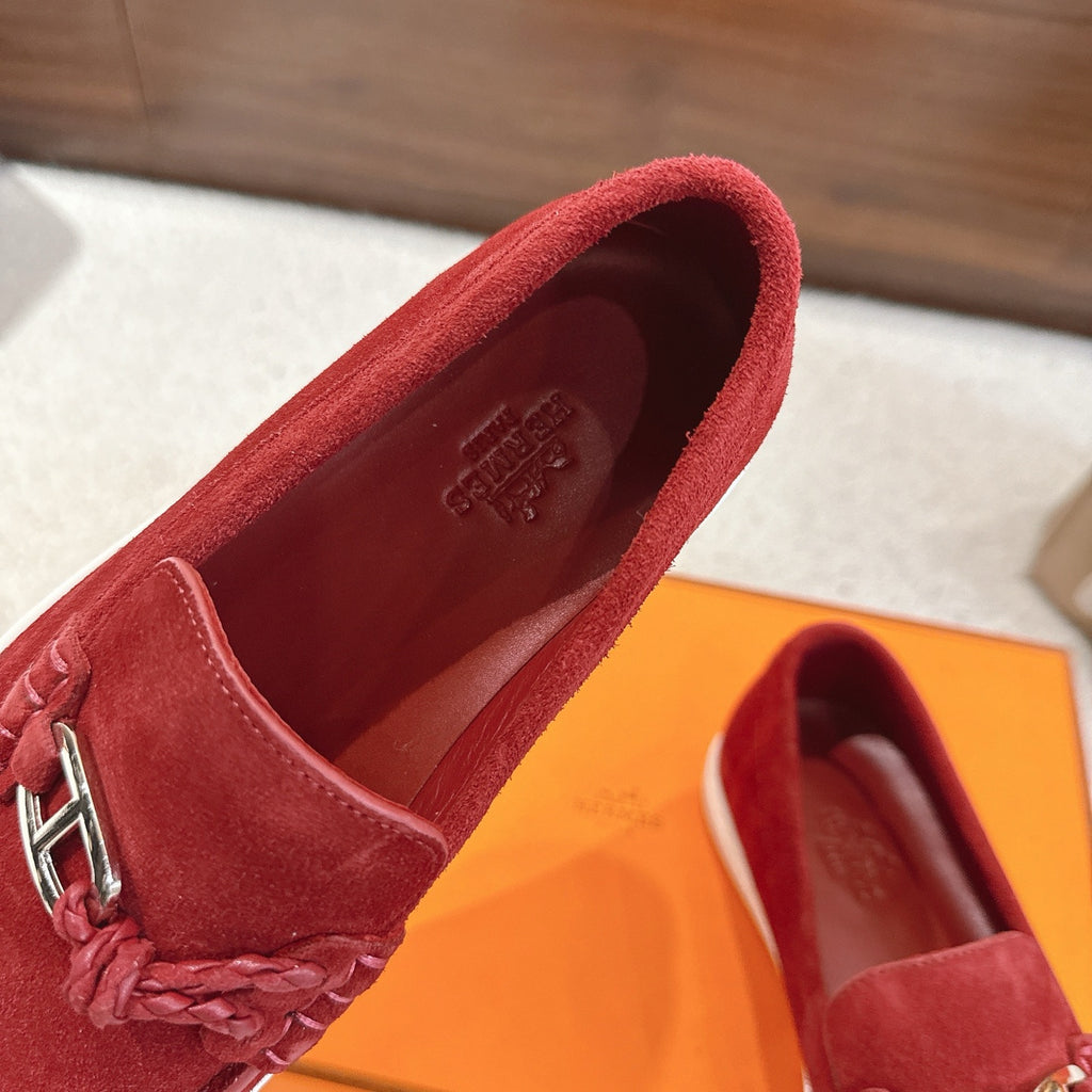 Hermes unisex red suede loafer close-up with braided detail and metal H bit