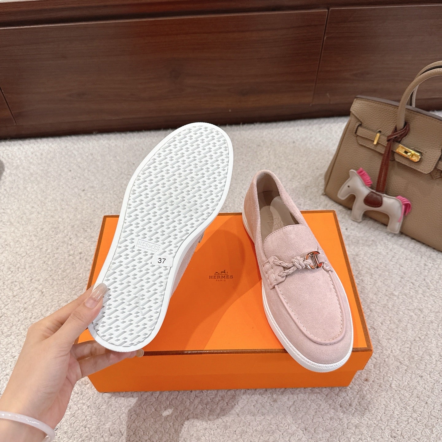 Hermes unisex light pink suede loafers with patterned outsole and silver-toned horsebit detail.