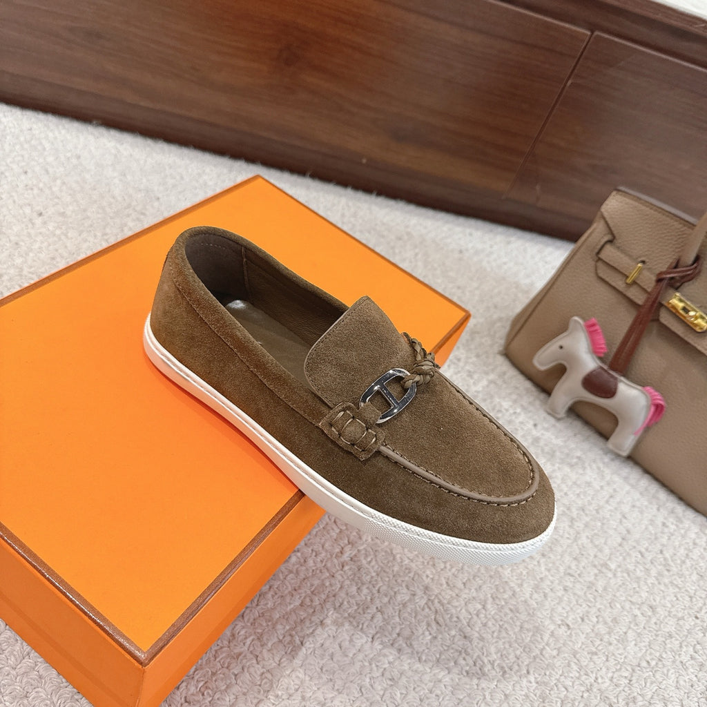 Suede slip-on loafers with metal bit clasp and white rubber sole, dark olive; angled view.