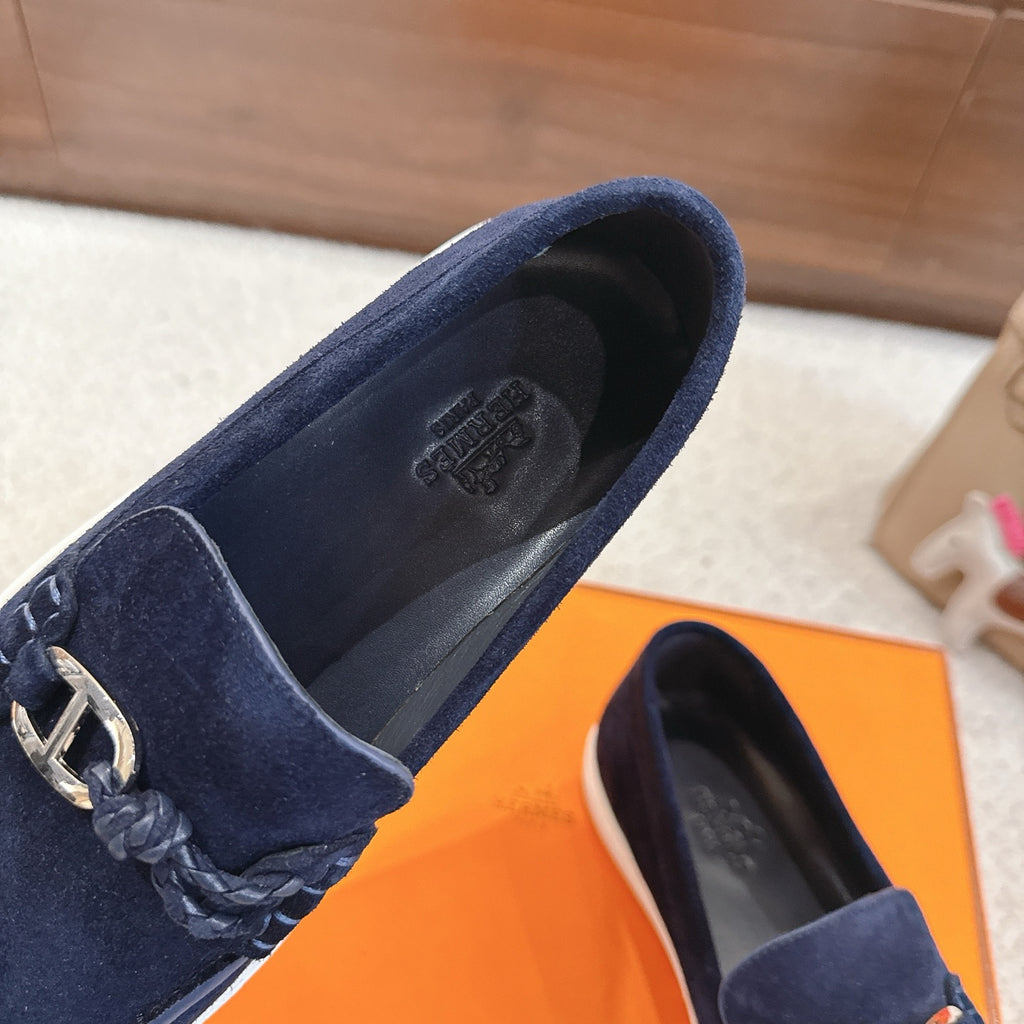 Hermes unisex navy suede loafer close-up, gold-tone bit, braided trim, white sole