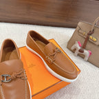 Hermes unisex tan leather loafer close-up, braided bit hardware and stitched sole edge