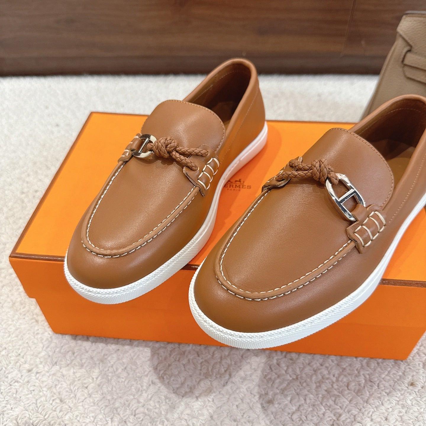 Hermes unisex tan leather loafers, front view with braided bit strap and white sole