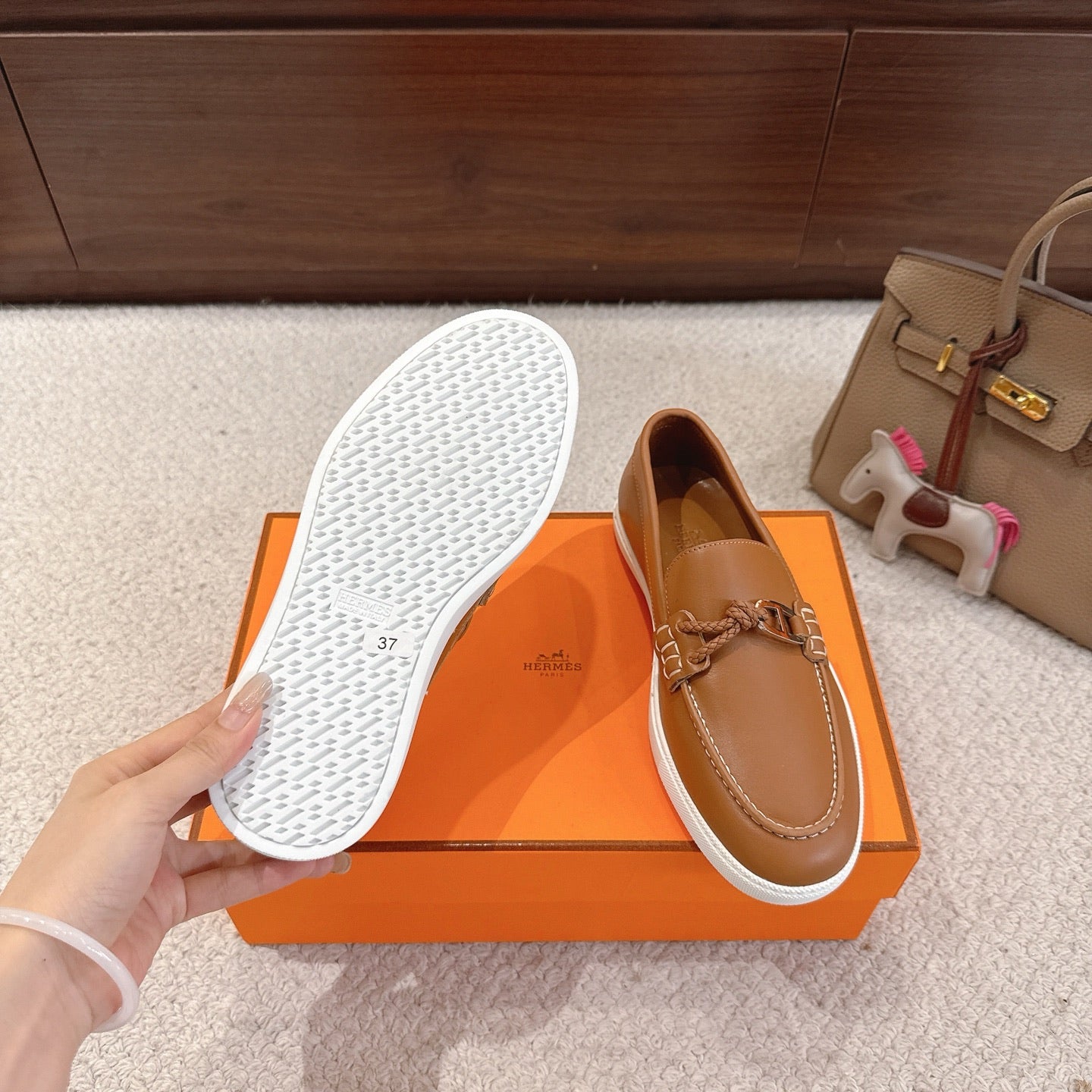Hermes unisex tan loafer with textured white outsole underside and braided bit vamp