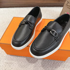 Hermes unisex loafers in dark leather with metal buckle strap and braided trim, white sole