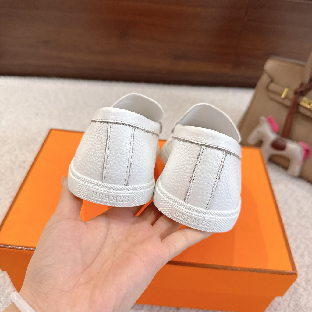 White leather loafer heel view with embossed logo on rubber sole