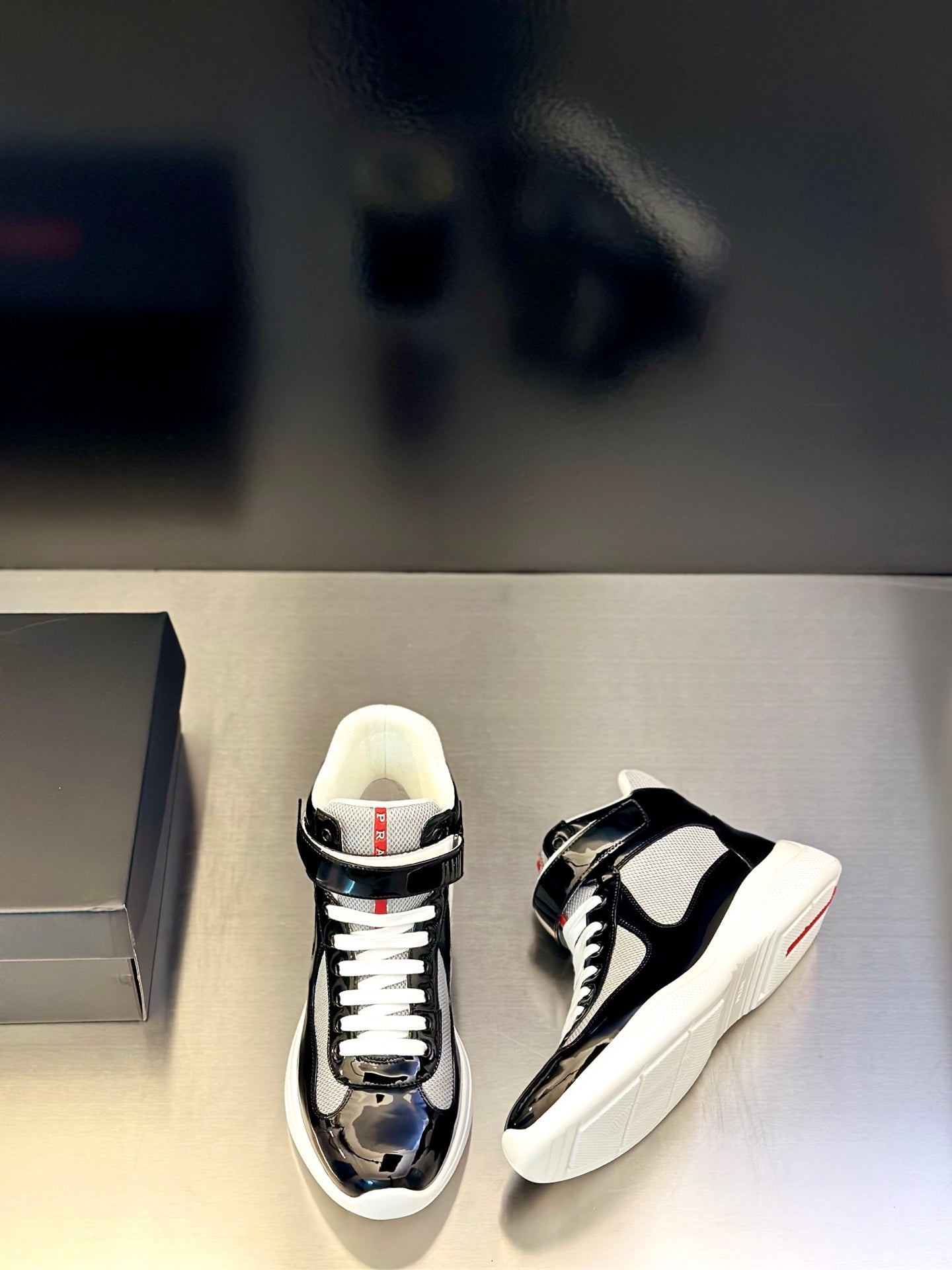Prada unisex sneakers, black glossy leather, white laces, side stripe detail, low profile