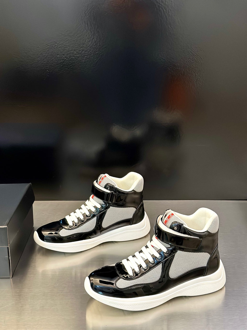 Prada unisex mid-top sneakers, black glossy finish, white laces, chunky white sole