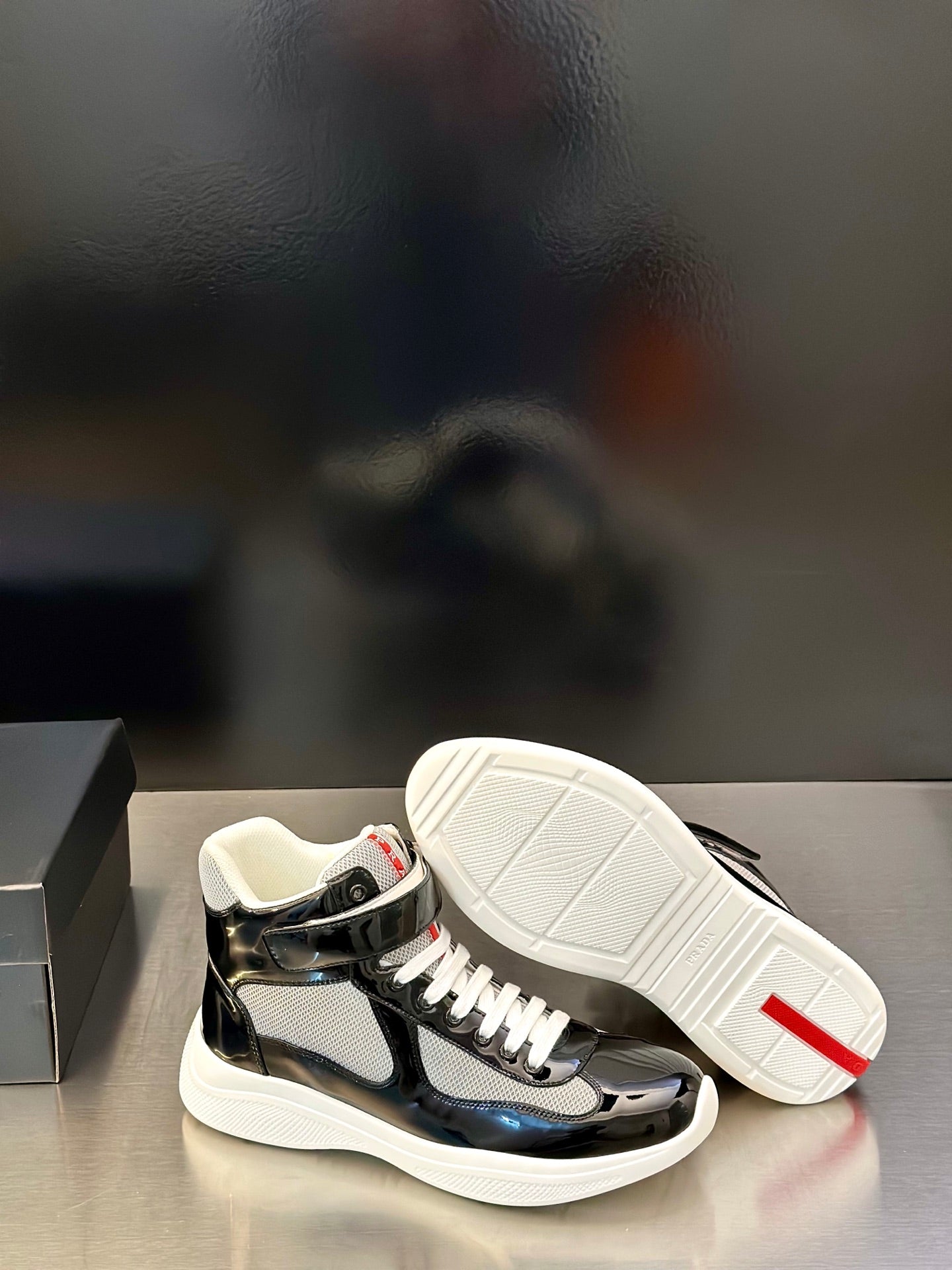Prada unisex sneakers, black glossy uppers with off-white outsole, lace-up design