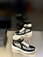 Prada unisex mid-top sneakers, black glossy upper, white contrast sole, lace-up style