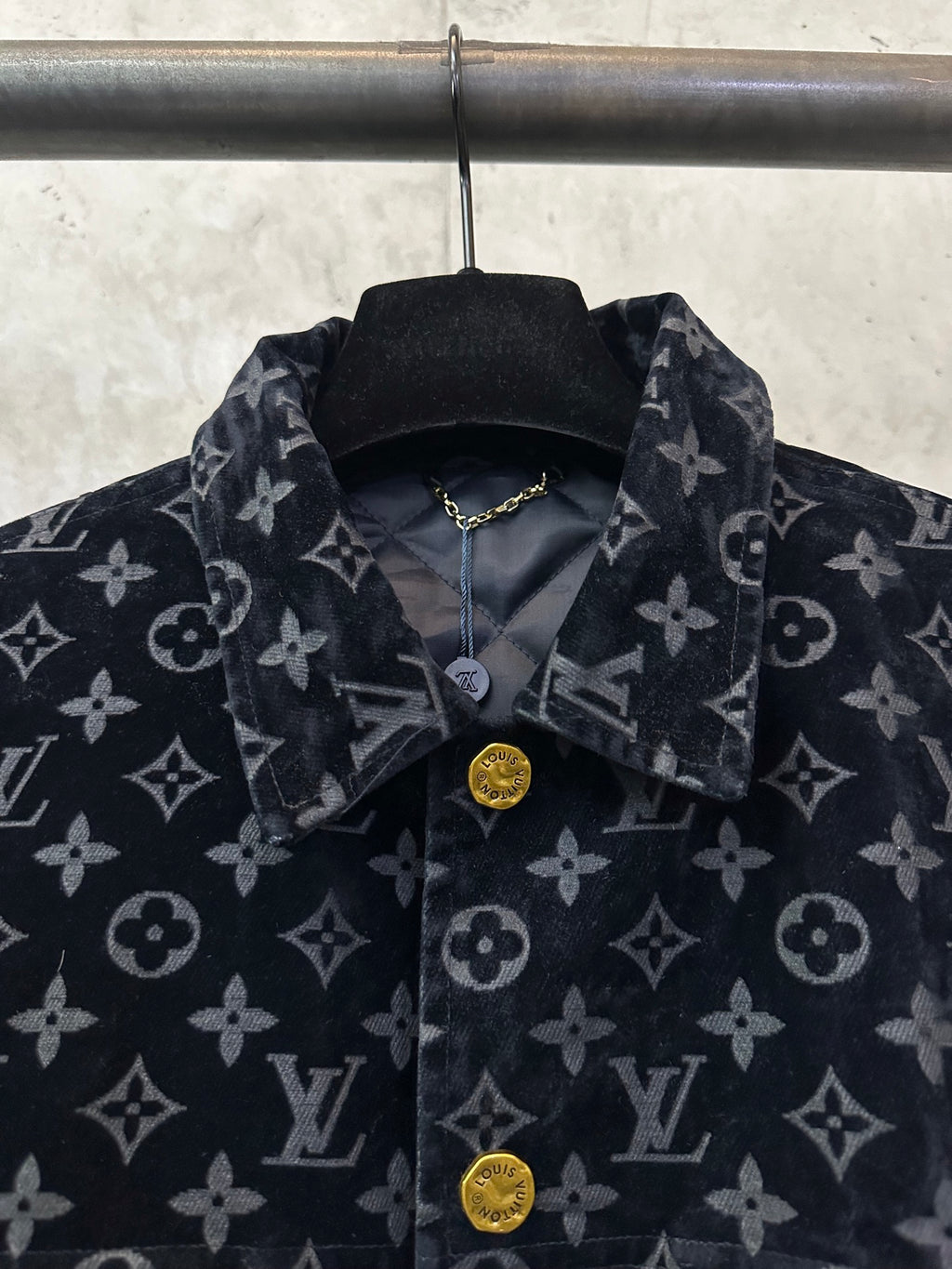 Long jacket collar and button placket close-up with dark monogram pattern