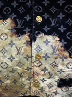 Long jacket fabric close-up showing dark monogram print and gold abstract sections