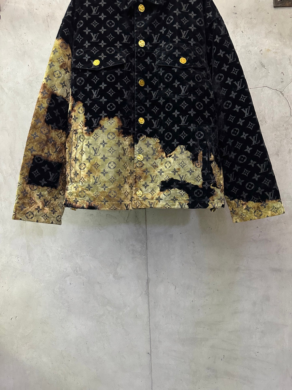 Long jacket with dark monogram pattern, gold buttons, and gold abstract lower panels