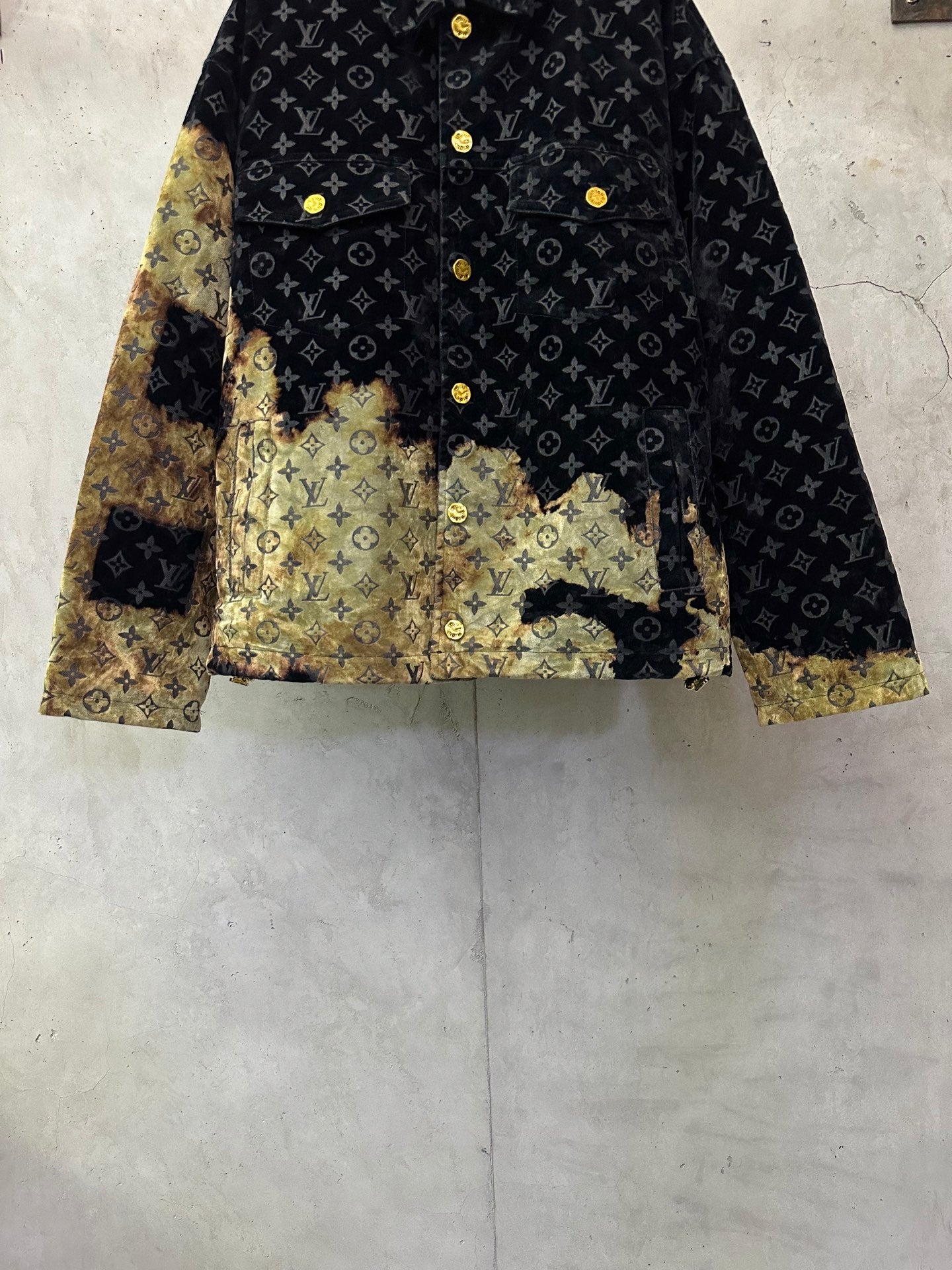 Long jacket with dark monogram pattern, gold buttons, and gold abstract lower panels