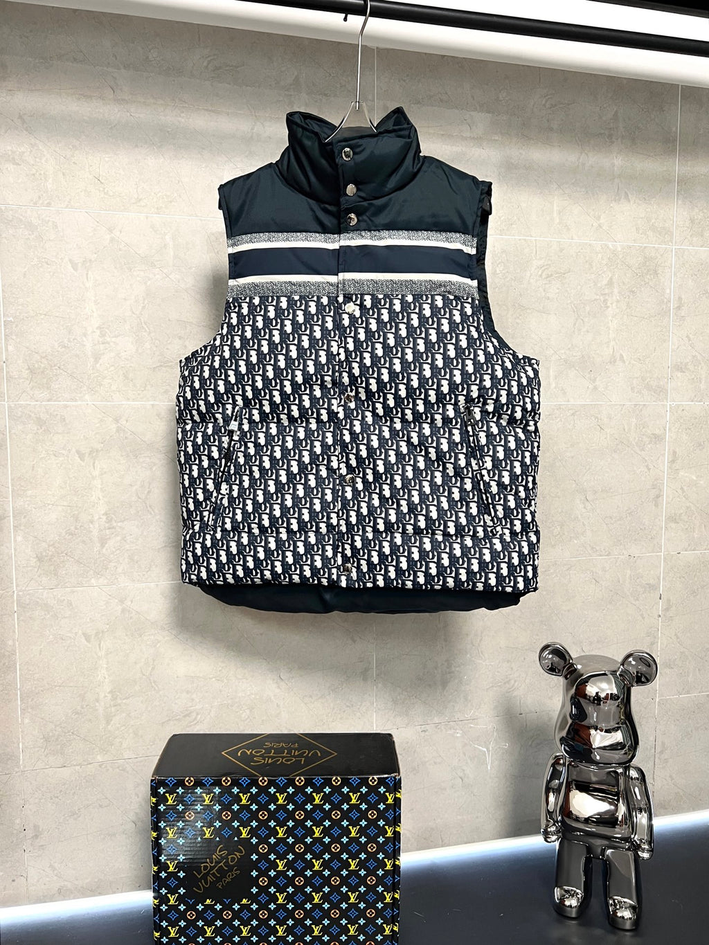 Sleeveless puffer vest with dark collar, white logo print panel, front snap buttons