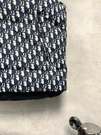 Logo-print puffer vest fabric with navy and white repeating monogram pattern