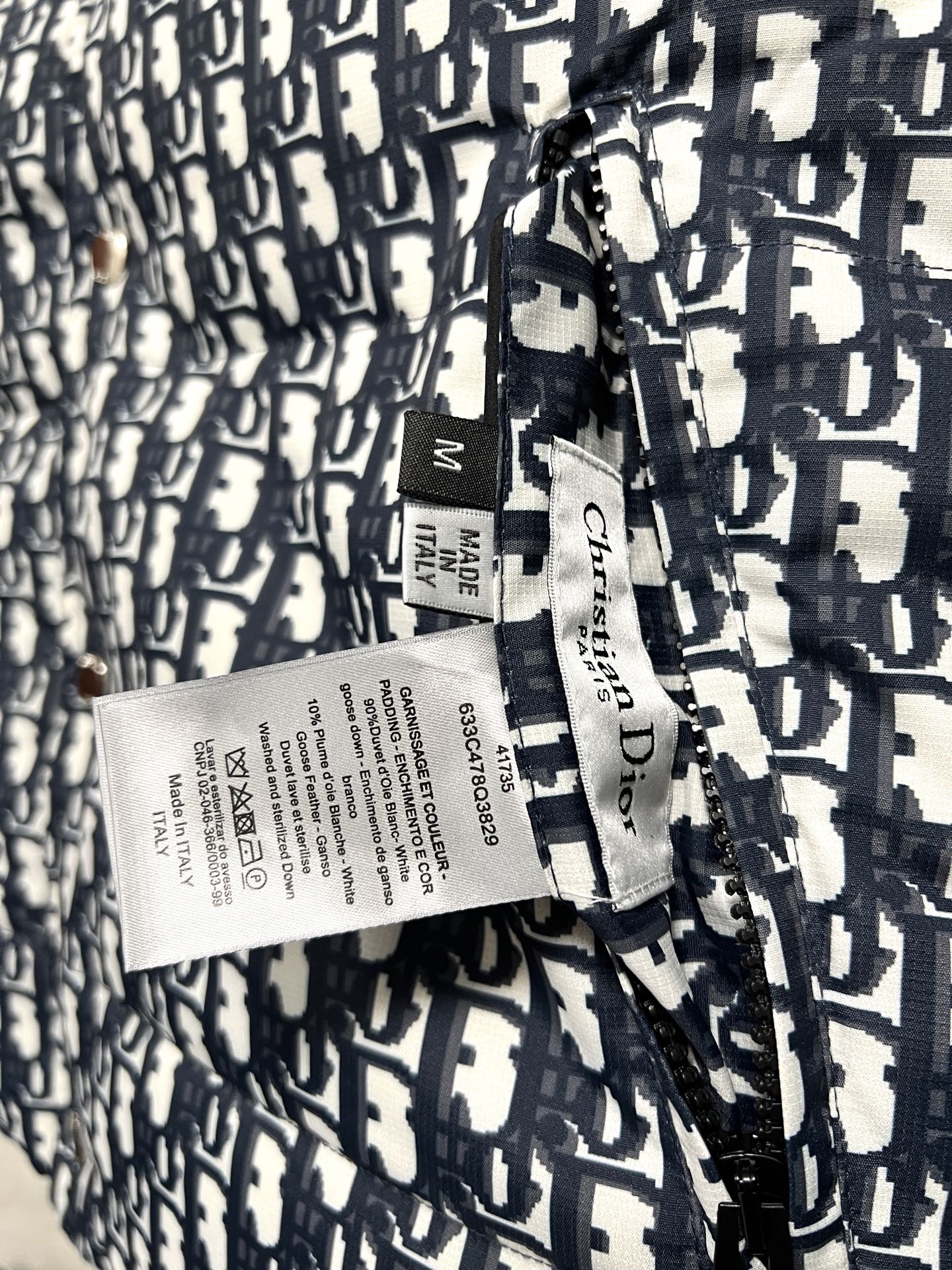 Puffer vest care label and size tag on logo-print fabric