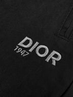 Black Dior pants fabric with Dior logo text on the front