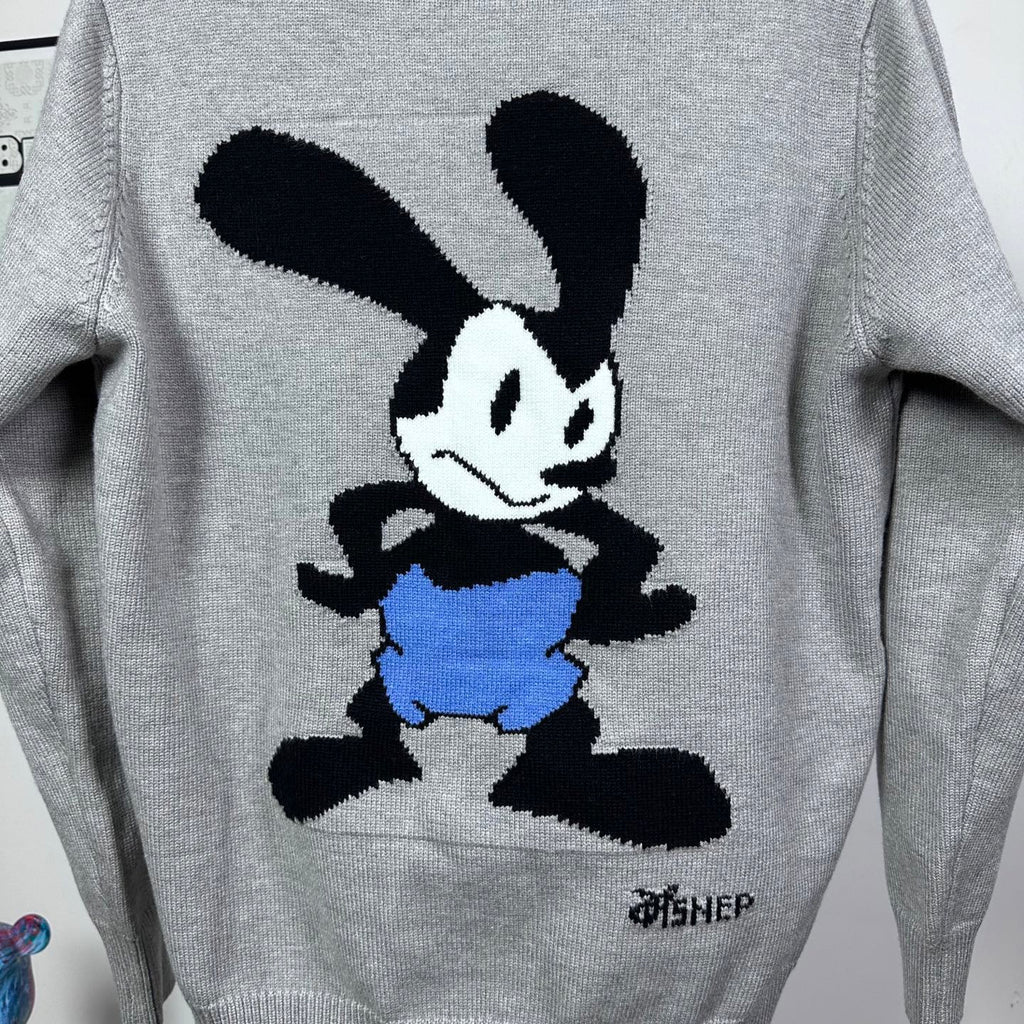 Grey knit sweater with Mickey Mouse graphic, blue shorts, and black details