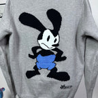 Grey knit sweater with Mickey Mouse graphic, blue shorts, and black details