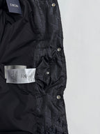 Dior long puffer jacket front close-up with Dior label, snap placket, dark monogram