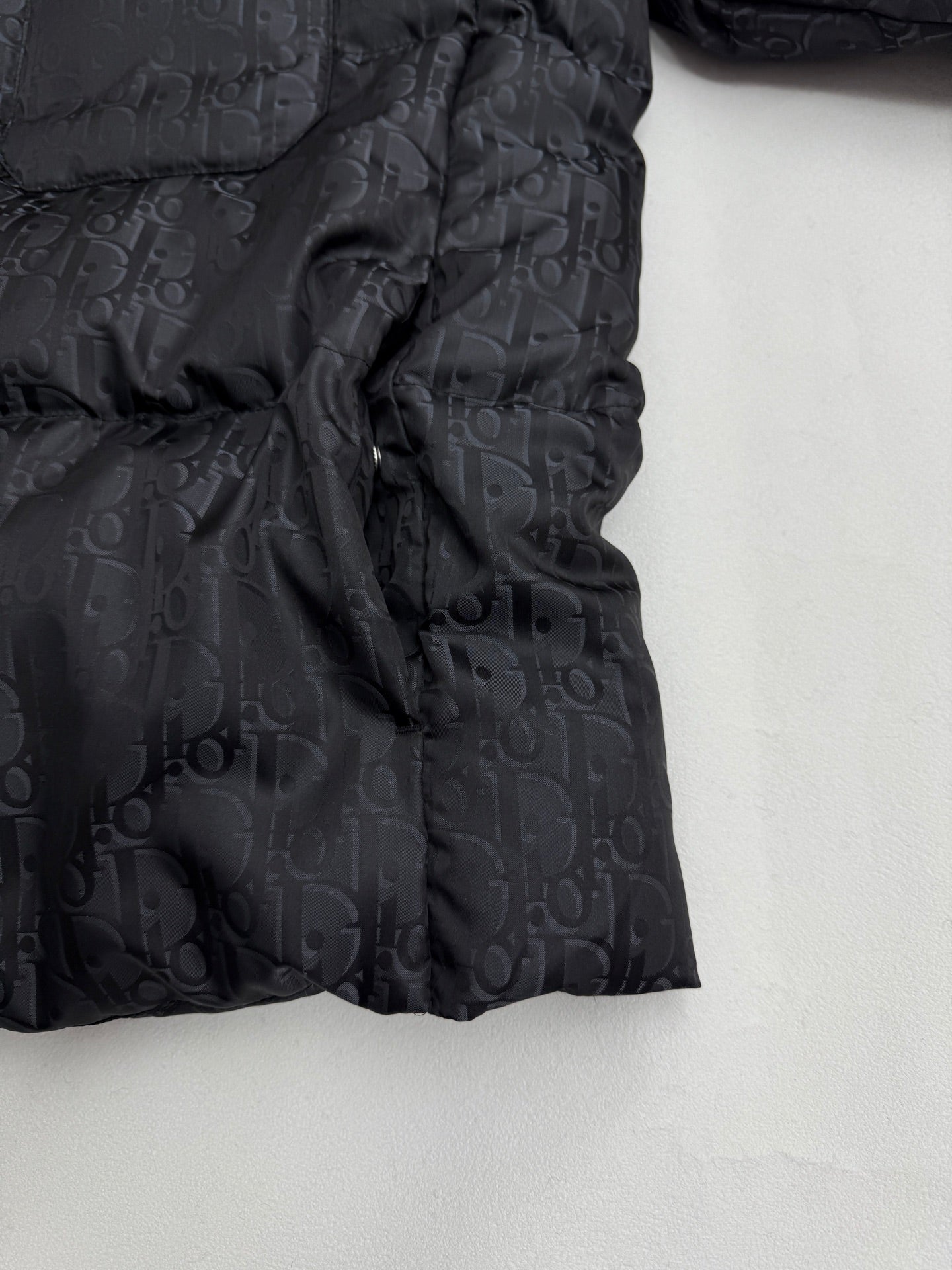 Dior long puffer jacket side view with gathered quilting and dark monogram pattern
