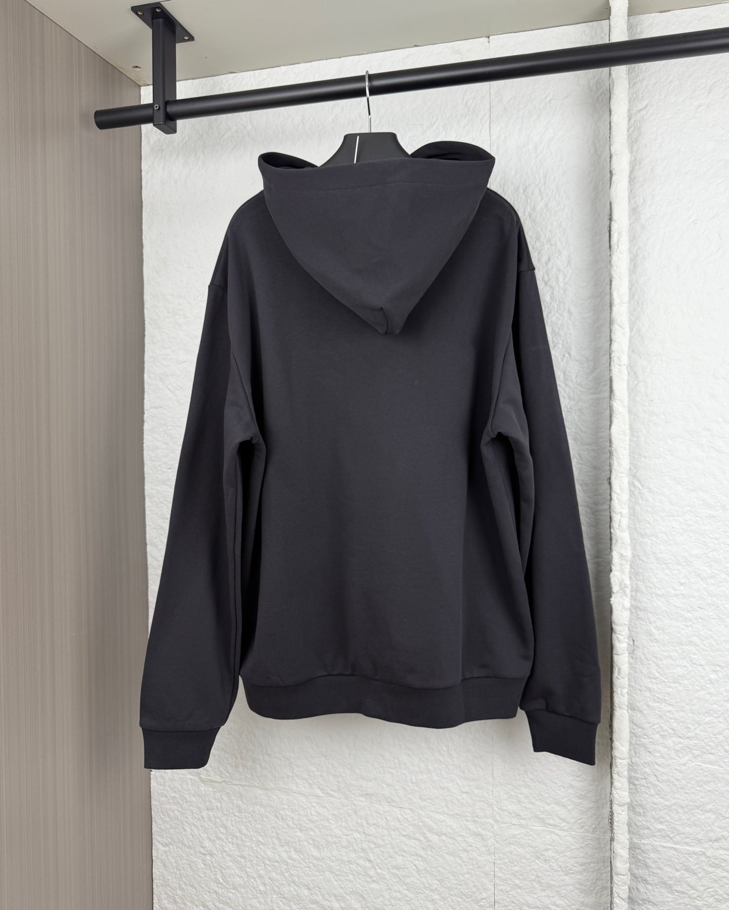 Black hoodie sweatshirt with attached hood and kangaroo pocket, back view