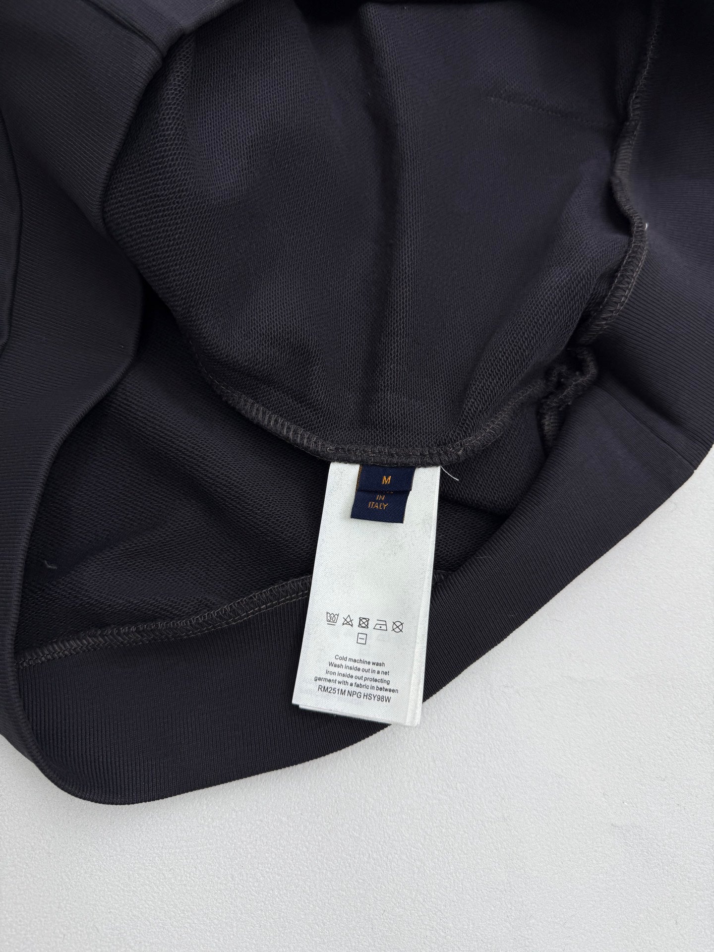 Black hoodie neckline with inner brand label and drawstring channel