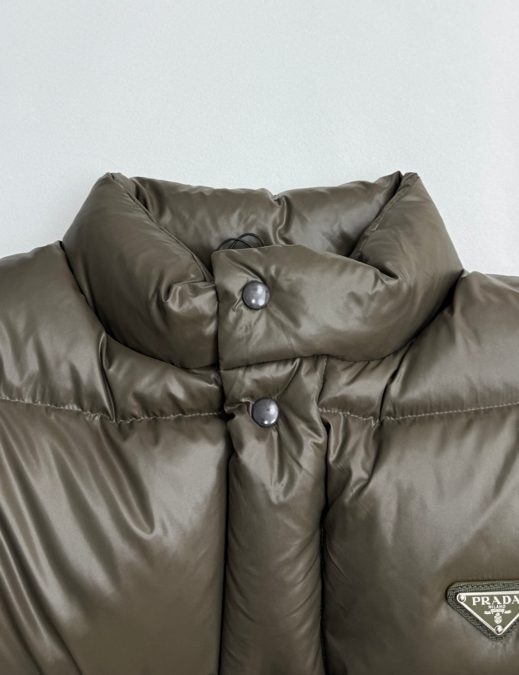Prada puffer jacket collar in olive with snap buttons and glossy quilted fabric
