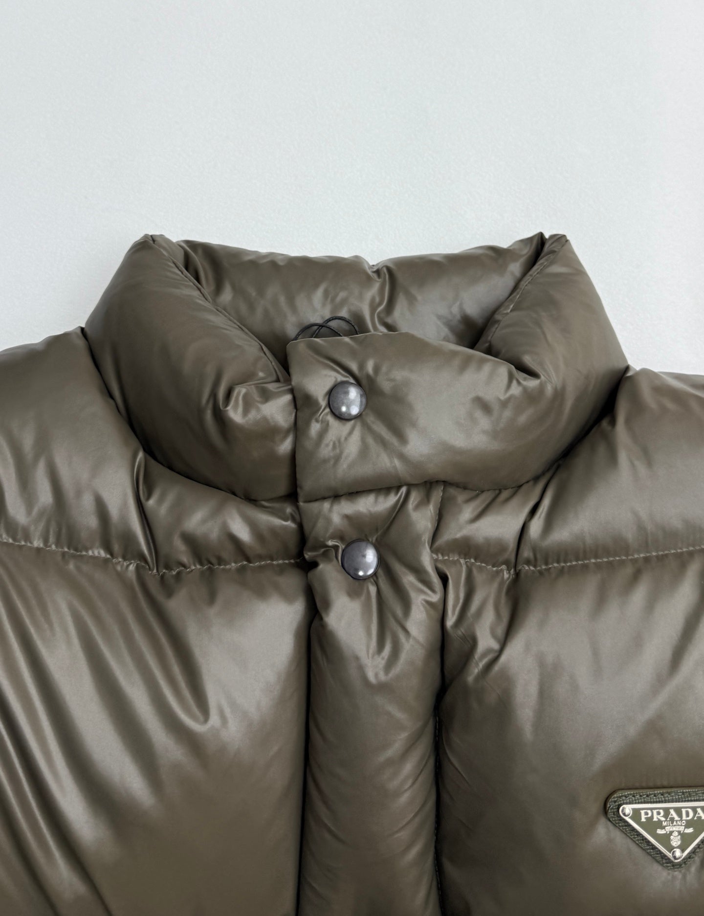 Prada puffer jacket collar in olive with snap buttons and glossy quilted fabric
