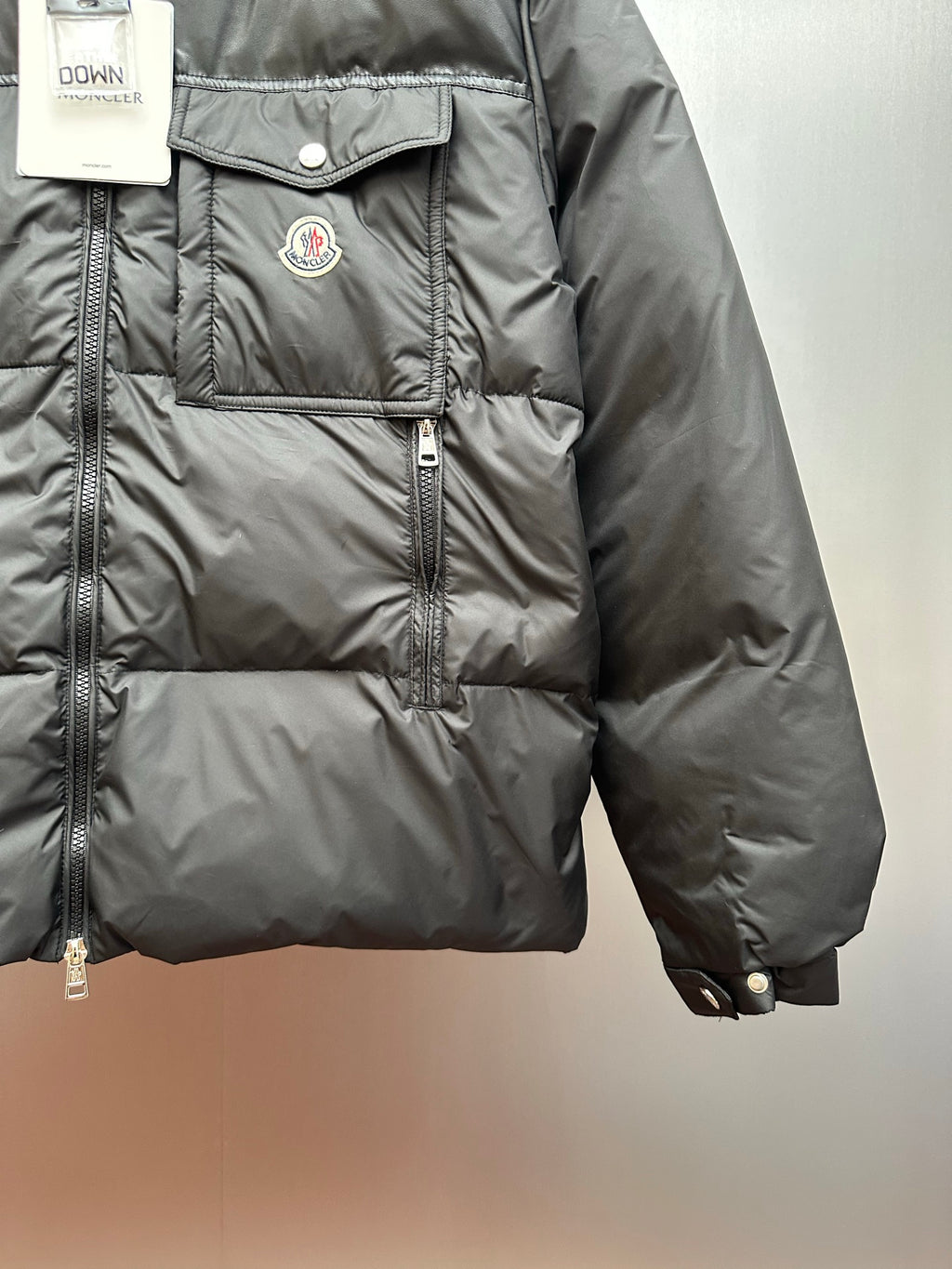 Moncler long puffer jacket front panel with logo patch and zipper placket