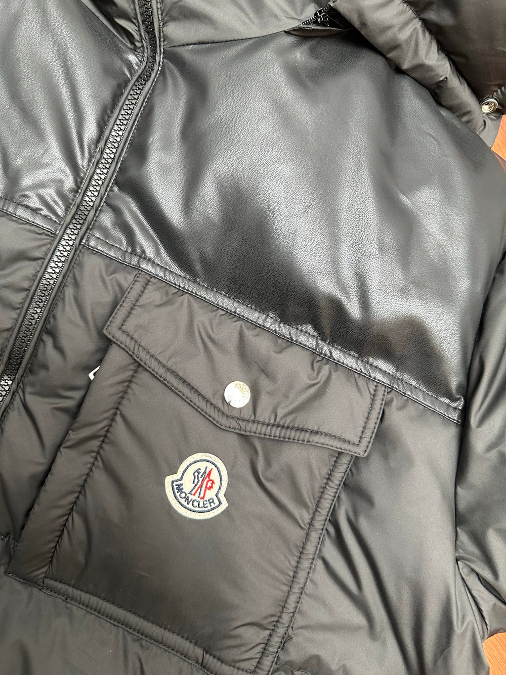 Moncler long puffer jacket detail, logo patch and buttoned chest pocket