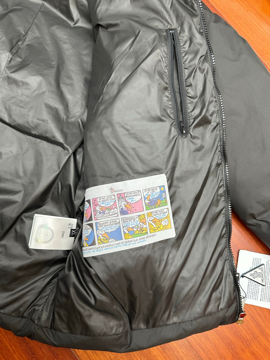 Moncler long puffer jacket close-up of zipper track and size/brand tags