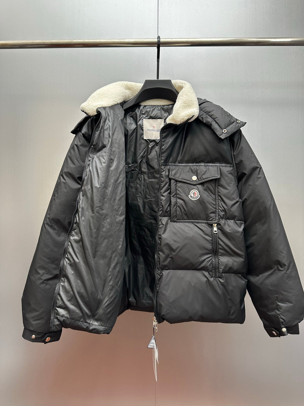 Moncler long puffer jacket front view, faux shearling hood and logo patch