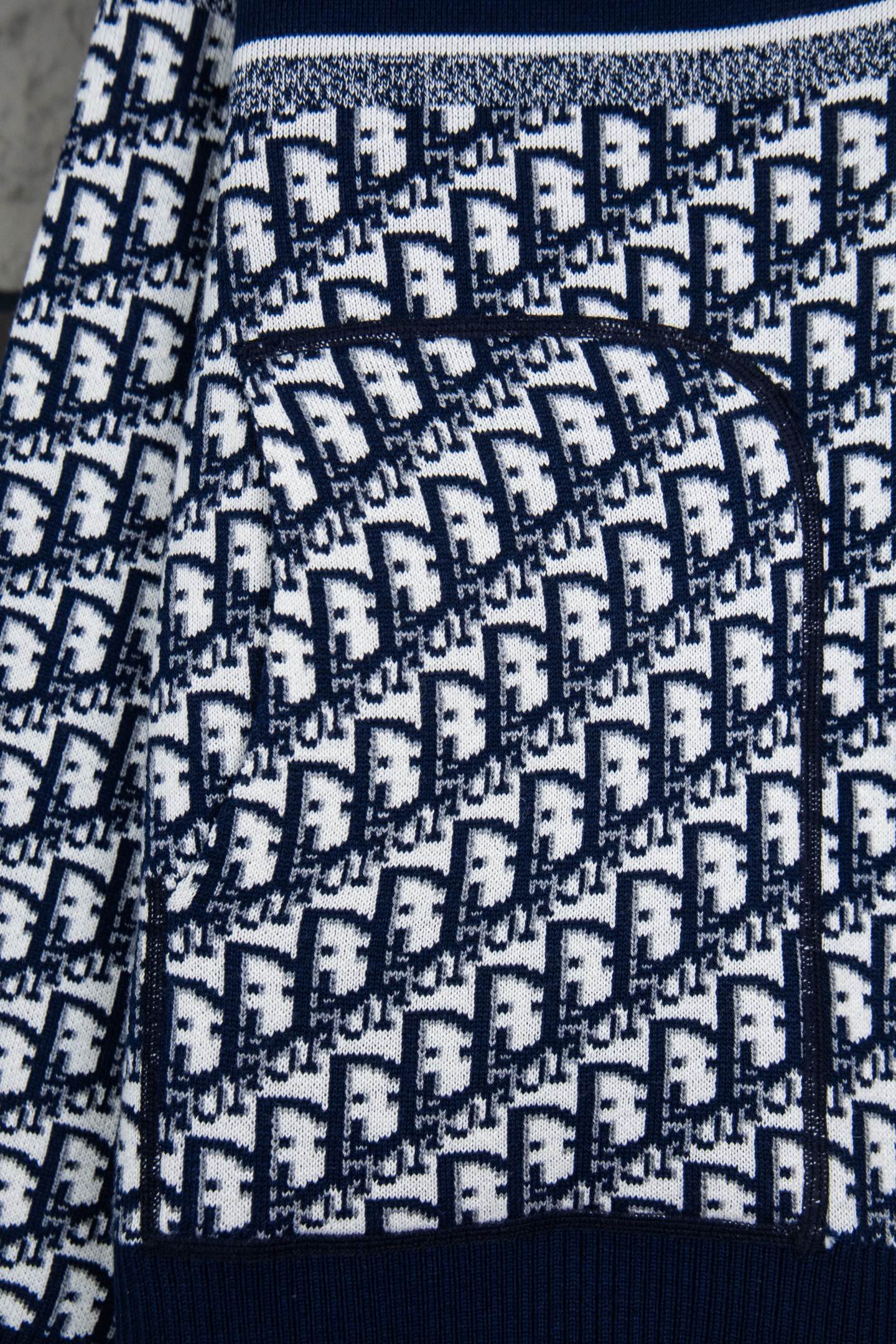 Dior long-sleeve knit sweater pattern close-up with navy ribbed cuff