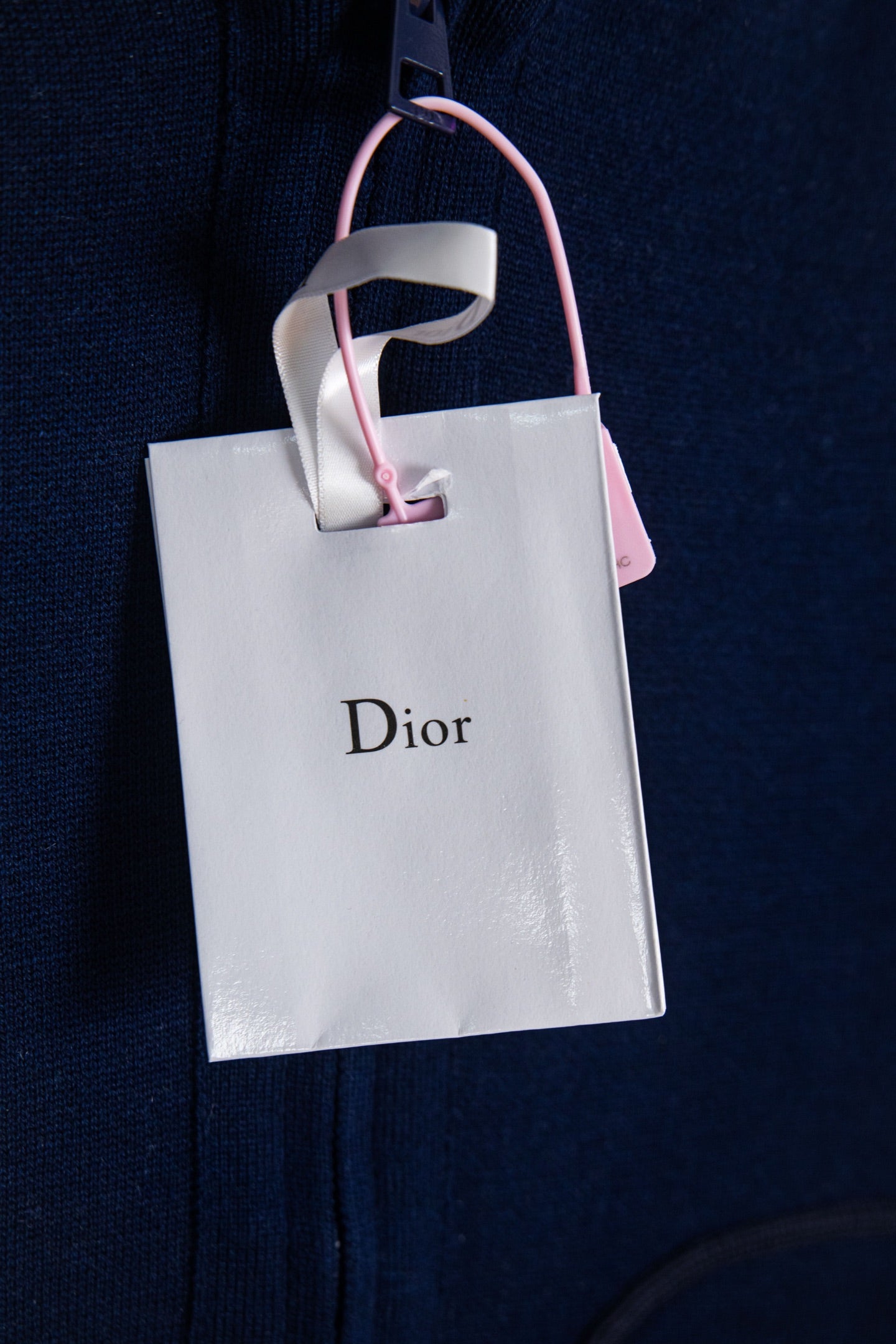 Navy Dior zip-up hoodie sleeve with Dior shopping bag tag