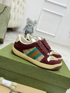 Burgundy and cream Gucci low-top sneakers with striped panel and lace-up front