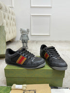 Gucci low-top sneakers, dark gray uppers with red-yellow-green stripe detail and black laces