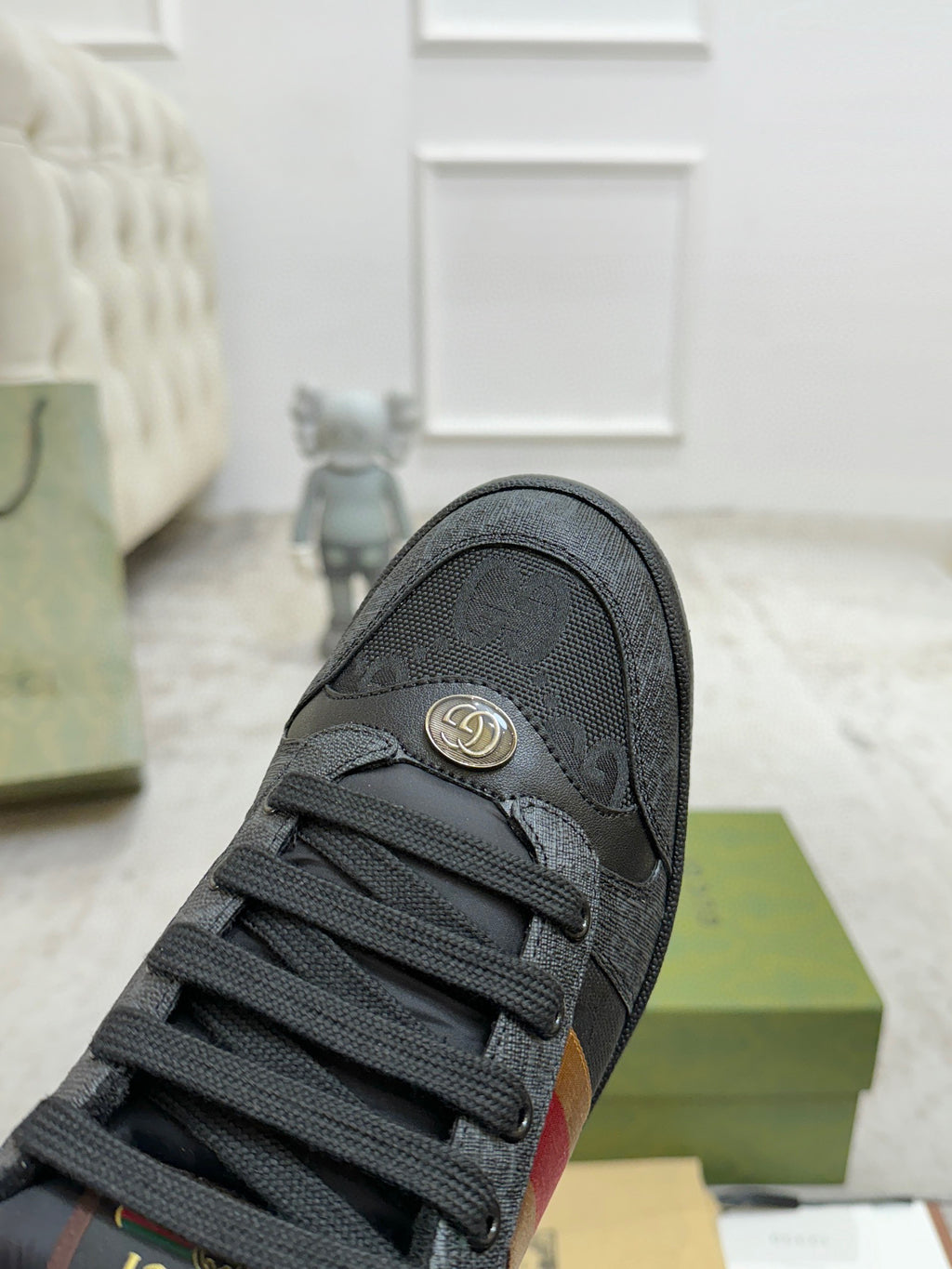 Gucci low-top sneaker toe and lace area in dark gray with small emblem near heel