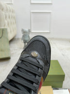 Gucci low-top sneaker toe and lace area in dark gray with small emblem near heel