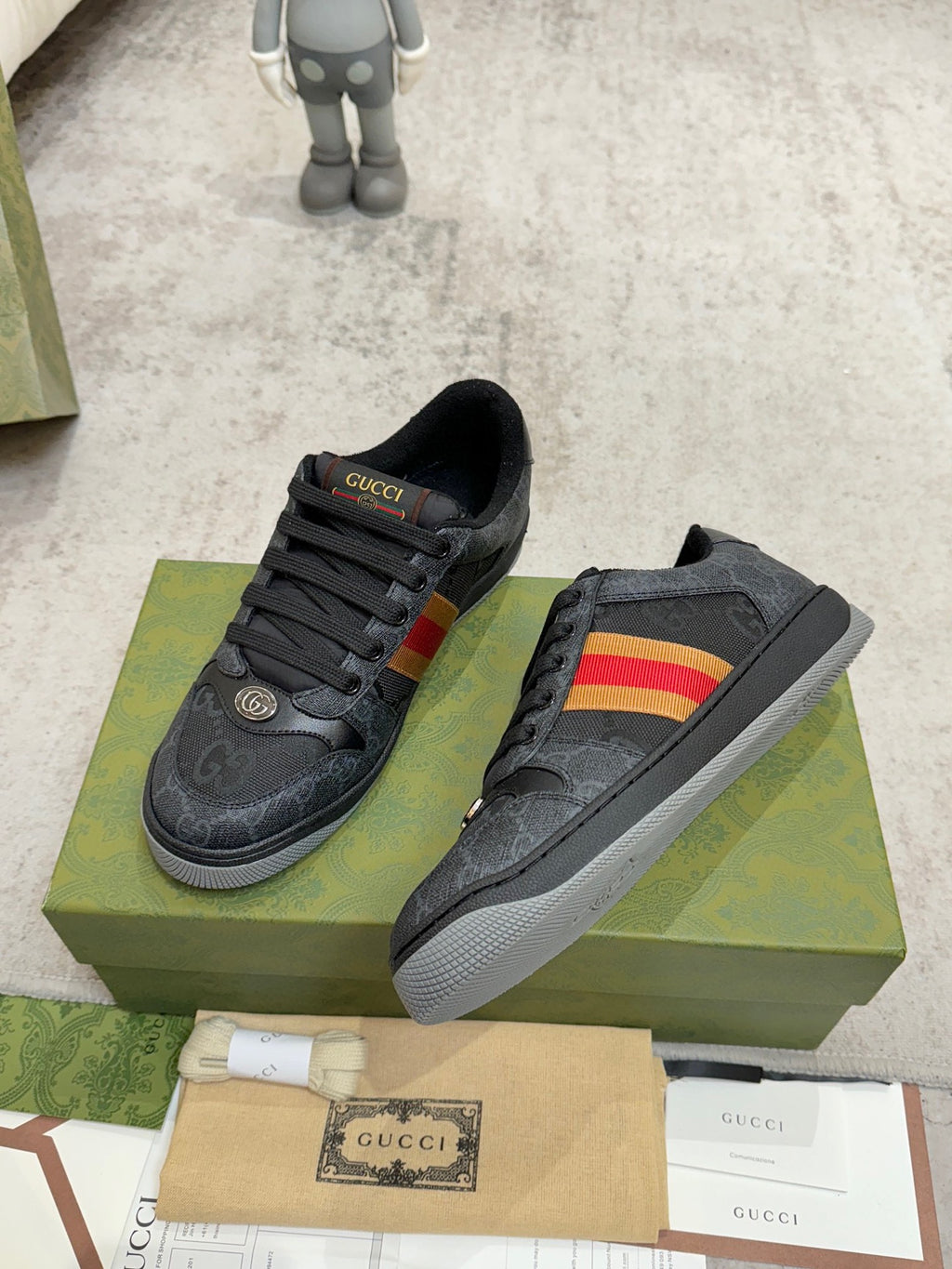 Gucci low-top sneakers pair, dark gray with multicolor stripe panel and black lace uppers