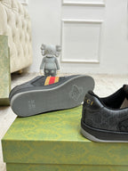 Gucci low-top sneaker outsole with tread texture and dark gray upper on display boxes