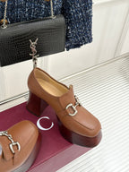 Gucci tan leather heeled loafers angled view, silver horsebit hardware and block heel