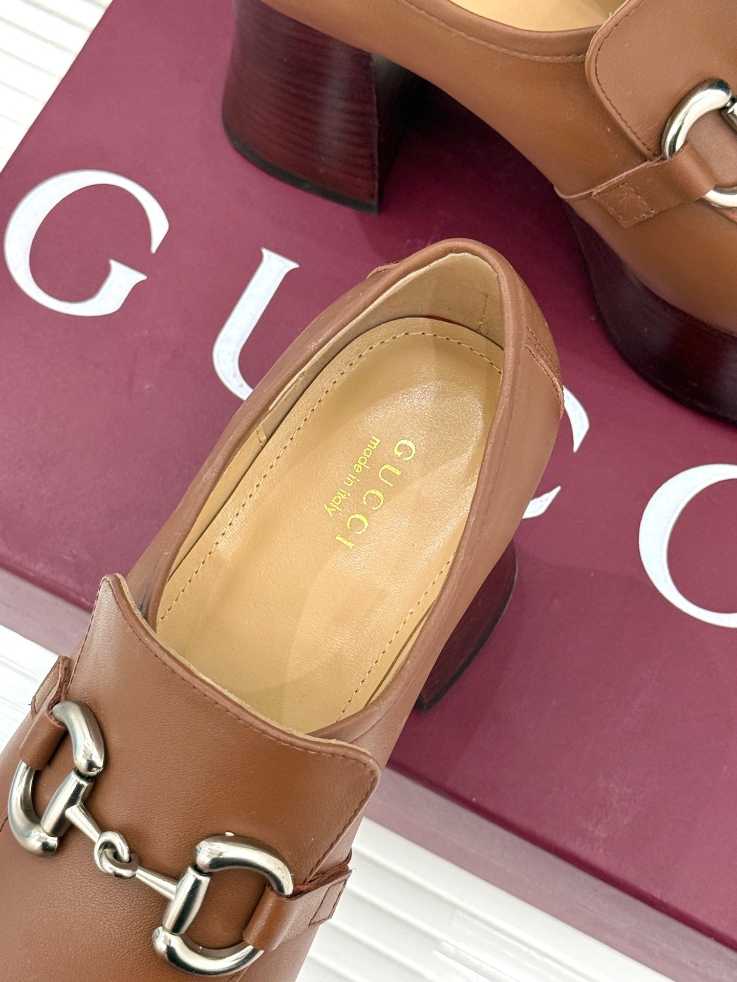 Gucci tan leather loafer close-up, silver horsebit hardware and cushioned insole