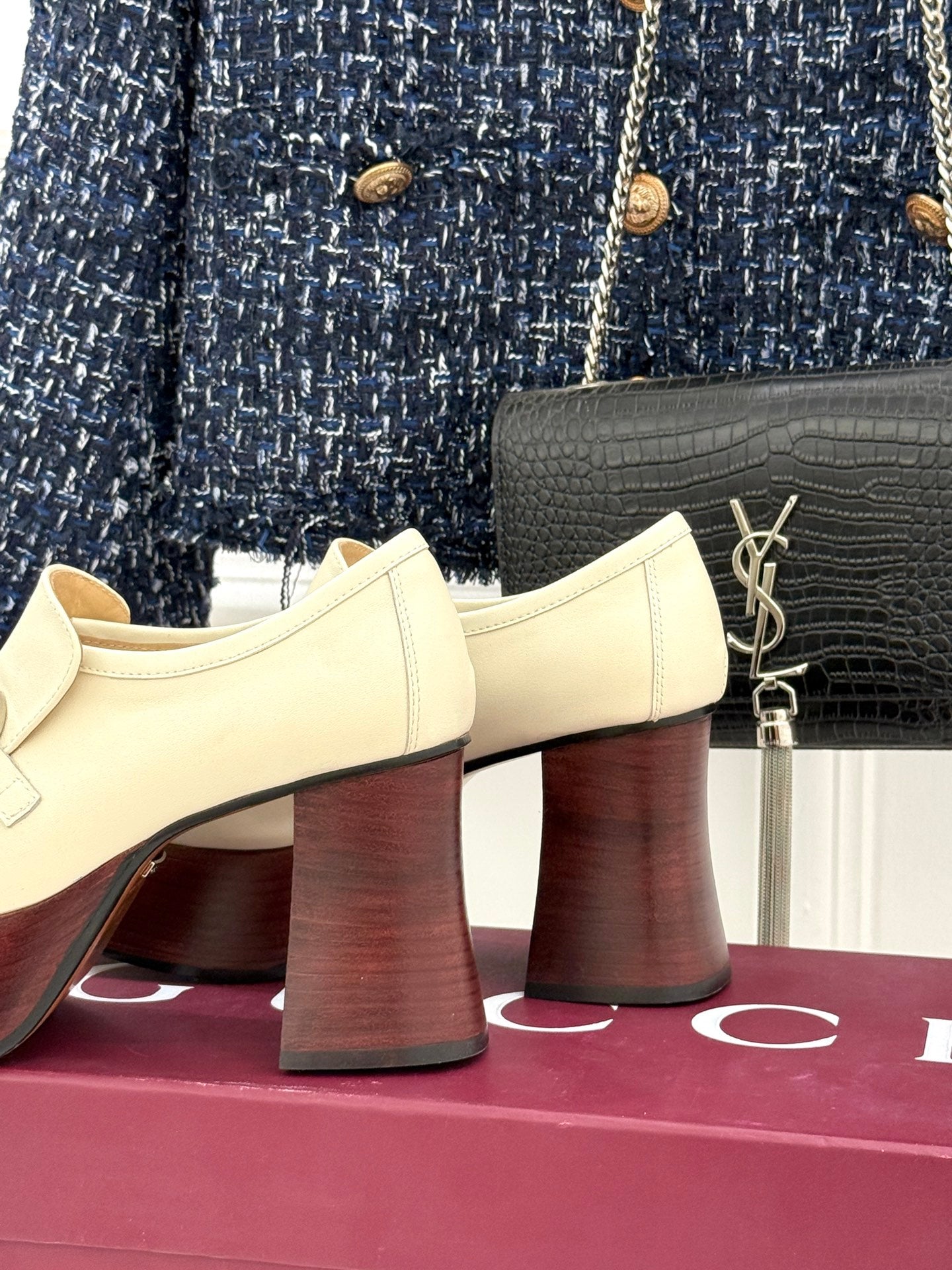 Cream Gucci heeled loafers with metal horsebit detail and dark red block heels, side view