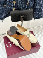 Cream Gucci loafers with metal horsebit detail, opened instep showing tan lining