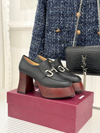 Black leather platform loafers with chunky block heels and silver chain hardware