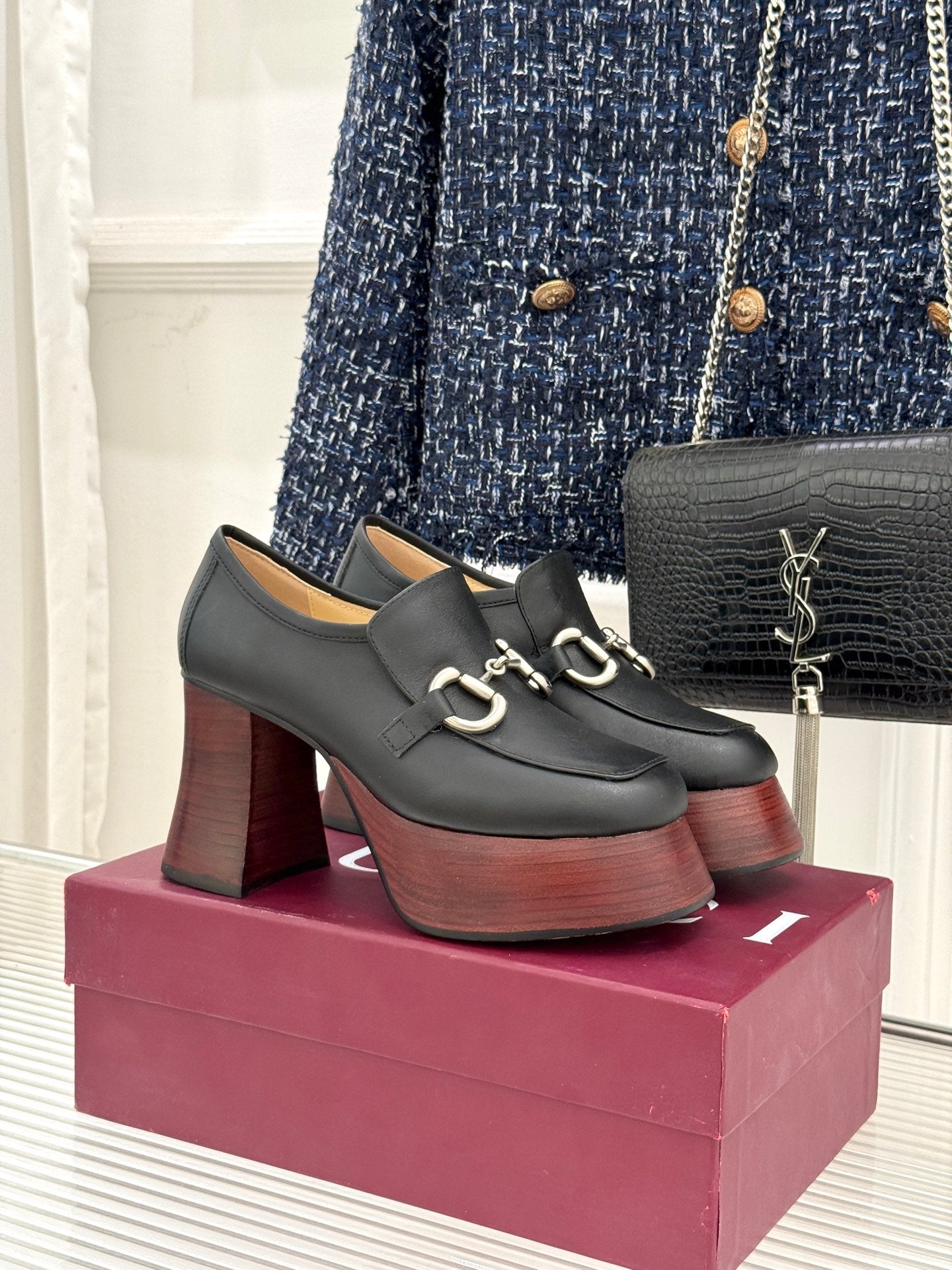 Black leather platform loafers with chunky block heels and silver chain hardware