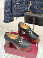 Pair of black leather loafers with chunky block heels and silver chain-link hardware