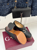 Black leather platform loafers with chunky heels and silver chain-link hardware